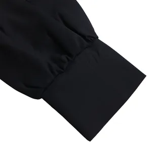 Primer plano de la manga plisada y el puño ancho de este vestido camisero negro