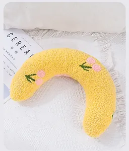 Close-up of plush U-shaped pet pillow with embroidered cherry pattern for neck protection
