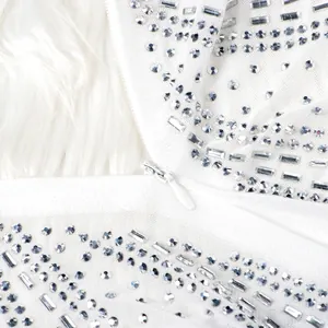 Detailed view of rhinestones and invisible zipper on white evening dress
