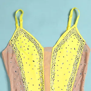 Detailed view of yellow rhinestone camisole dress with sheer mesh paneling