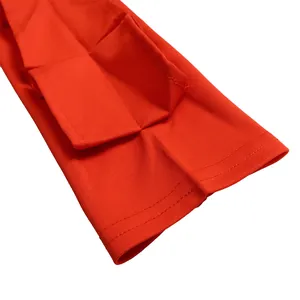 Macro view of bright red long sleeve dress showing pocket flap and stitching details