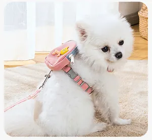 Detalle del arnés rosa para mascotas con mochila pequeña en un Pomerania blanco.