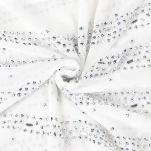 Close-up macro view of white mesh fabric with intricate silver rhinestone embellishments