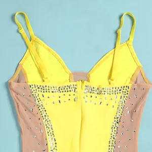 Detailed view of the rhinestone patterns and sheer mesh panels on yellow dress