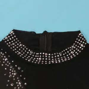Dettaglio dello scollo della tuta in rete nera con decorazioni in strass scintillanti