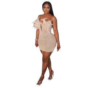 Detailansicht eines sexy champagnerfarbenen Bodycon-Kleids mit Federn und Perlenverzierung