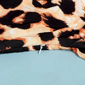 Detailed macro view of white invisible zipper on slim fit leopard print dress fabric