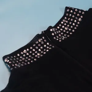 Vista dettagliata del colletto con strass scintillanti e zip su un body nero elegante
