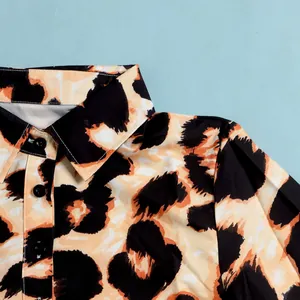 Detailed close-up of a leopard print dress featuring a lapel collar and black buttons