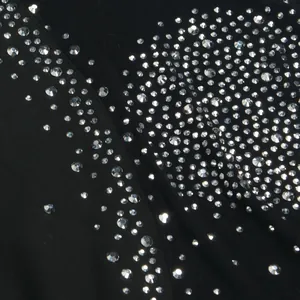 Vista macro che mostra i dettagli di strass scintillanti sul tessuto nero della tuta sexy.