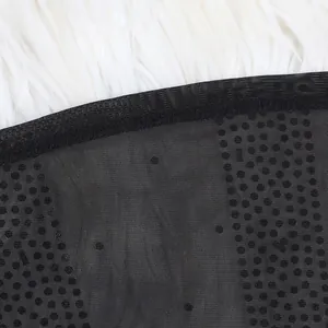 Close-up detail of black mesh fabric with hot-fix rhinestone pattern on fur background