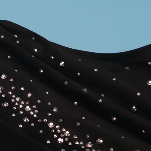 Primo piano di strass argentati scintillanti su un elegante tessuto a rete nero