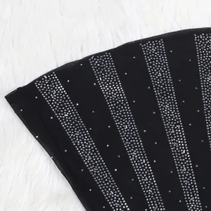 Close-up detail showing vertical silver rhinestone stripes on black mesh evening gown fabric