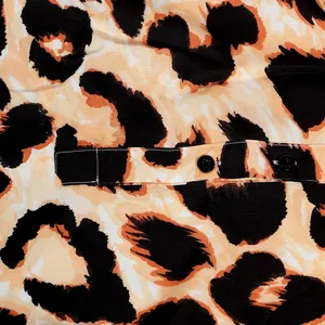 Macro detail view showing leopard print pattern and black buttons of a slim dress