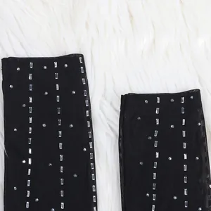 Close-up detail of silver rhinestones on black mesh material for a sexy evening dress