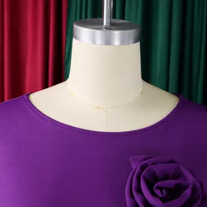 Robe violette à col rond élégante avec une grande rose en tissu détaillée sur le buste.