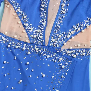 Dettaglio di perle bianche e strass scintillanti su tuta blu con inserti in rete