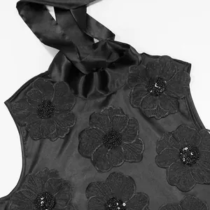 Dettaglio di abito nero senza maniche con eleganti applicazioni floreali 3D e paillettes brillanti