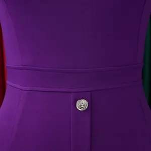 Détail d'une robe moulante violette avec un bouton décoratif en argent gaufré