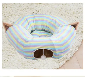 Dettaglio di un letto a tunnel per gatti a strisce colorate con orecchie di peluche