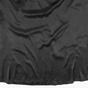 Primo piano del tessuto in raso nero con ricamo floreale su abito senza maniche