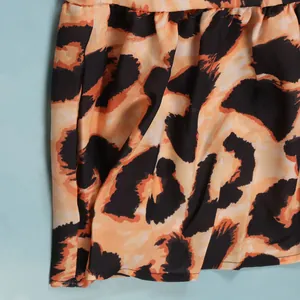 Detailed macro shot showing the leopard print pattern and texture of the dress fabric