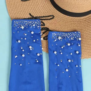 Dettaglio ravvicinato di tessuto blu con perle eleganti e strass scintillanti.