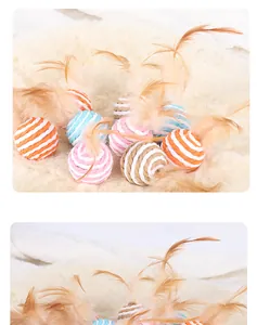 Detail view of colorful paper rope cat toy balls with natural feathers on fur rug