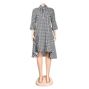 Full view of black and white houndstooth dress with lapel collar and high-low hemline