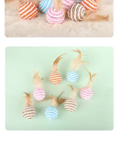 Group of colorful paper rope cat balls with natural feathers on a mint green background.