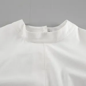 Detailed close-up view of the elegant minimalist mock neck on a white cotton linen dress