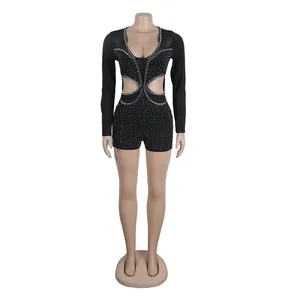Elegante tuta nera sexy a maniche lunghe con strass e ritagli in vita su manichino.
