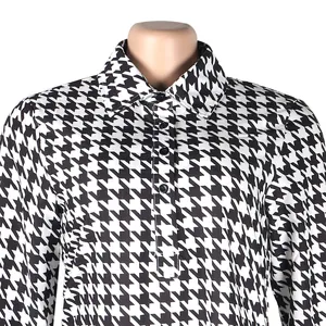 Close-up detail of black and white houndstooth pattern lapel shirt dress
