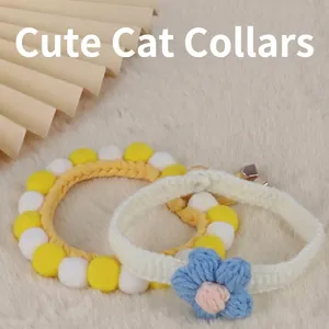 Handmade knitted pet cat collar featuring colorful pom-poms and a blue puff flower