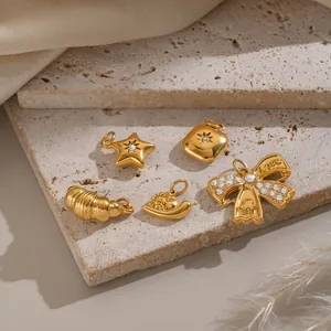 Collezione di ciondoli in acciaio inossidabile placcato oro 18k con forme di stella e fiocco.