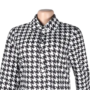 Detail view of the lapel collar and classic black and white houndstooth pattern dress