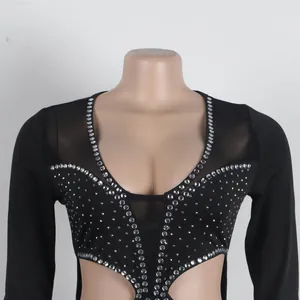 Dettaglio di una tuta in rete nera con strass e aperture cut-out di tendenza