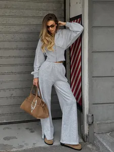 Ensemble de survêtement gris deux pièces élégant avec sweat à capuche et pantalon fendu.