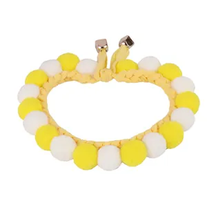 Yellow and white pompom knitted pet collar for cats and small dogs on white background