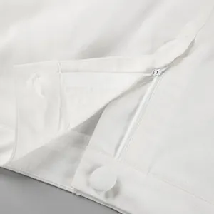 Detailed close-up of white cotton linen skirt with zipper and button closure