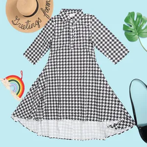 Close-up detail of a classic black and white houndstooth shirt dress with lapel collar