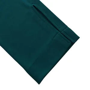 Gros plan sur la manche de la robe sarcelle avec passe-pouce et coutures de précision