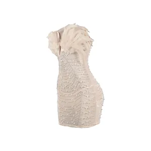 Detailansicht eines sexy Bodycon-Minikleides mit Federn, Strasssteinen und Perlen