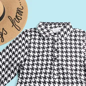Close-up of classic black and white houndstooth pattern dress with collar detail.