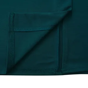 Vue macro montrant les coutures fines et la texture de cette robe vert émeraude
