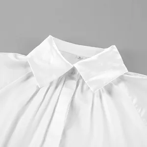 Primer plano detallado que muestra el cuello y la textura plisada de la blusa de satén