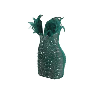 Elegantes smaragdgrünes Minikleid mit dekorativen Federn, Perlen und funkelnden Steinen.