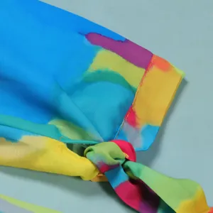 Macro view of a colorful watercolor print dress sleeve featuring a stylish knot detail