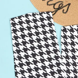 Macro detail of classic black and white houndstooth pattern on slim-fit dress fabric