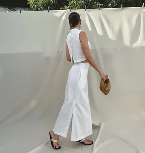 Back view of white linen two-piece set with buttoned sleeveless top and slit maxi skirt